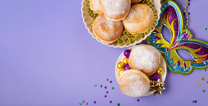 Mardi Gras King Cake Doughnuts or Donuts, Carnival Masks on Purple Background.