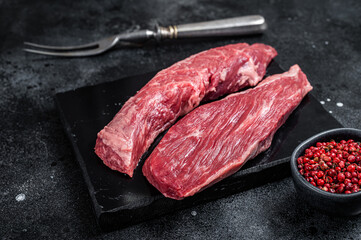 Bavette raw beef meat steak or Sirloin flap on marble board. Black background. Top view