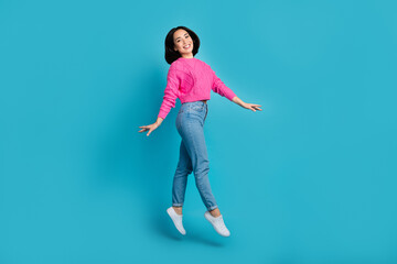 Fototapeta na wymiar Full length photo of sweet shiny lady wear pink pullover walking jumping high isolated blue color background