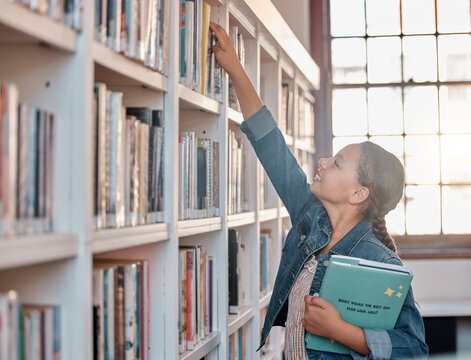 Books, education or child in a library to search for knowledge or development for future learning. Hand reaching, student growth or happy girl studying, information or searching for a story at school