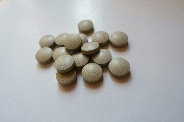 Fototapeta na wymiar Closeup of heap of beige round pills of iron bisglycinate dietary supplement