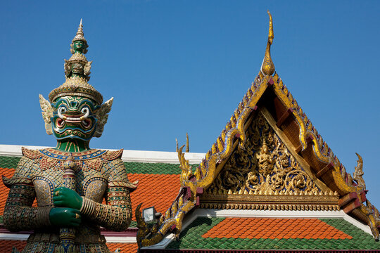 Low angle view of statue by Grand Palace against clear blue sky