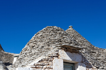 Fototapeta na wymiar Specific stone cone roofs in the city of Alberobello