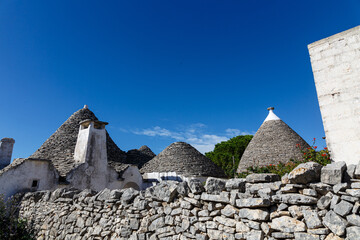Fototapeta na wymiar Specific stone cone roofs in the city of Alberobello