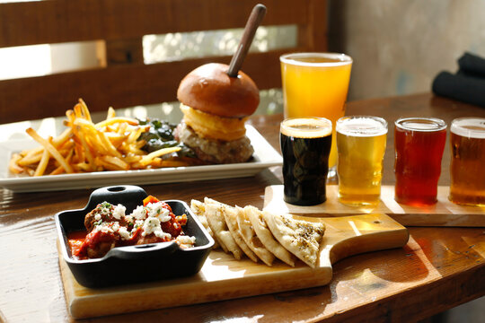 High angle view of fast food with beer served on wooden table in restaurant