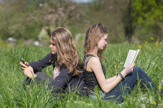 Teenage girls sitting in field, Freiburg im Breisgau, Baden-Württemberg, Germany
