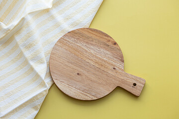 Small wooden cutting board placed on a yellow background