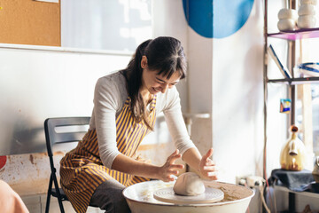 Female artisan shaping clay in a pottery workshop