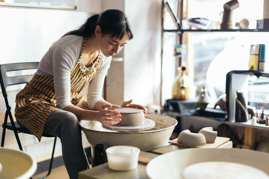 Female artisan shaping clay in a pottery workshop