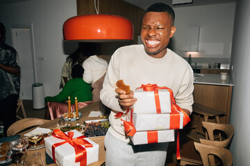 Man Eating Cookie and Holding Presents
