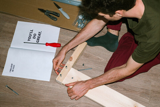 Man assembles new wooden bed after home delivery 