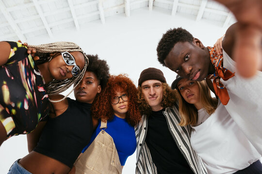 Cool friends in trendy clothes posing in studio