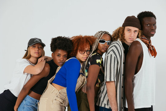 Cool friends in trendy clothes posing in studio