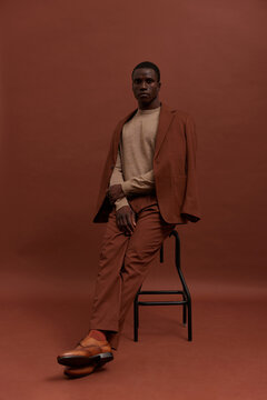 Man in suit sitting on stool
