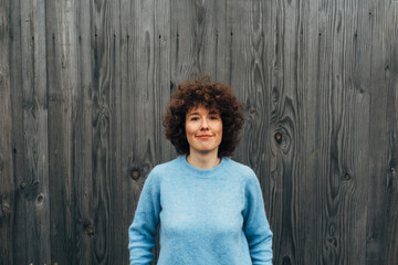 Portrait of Beautiful Smiling Red Haired Woman on Wooden Background