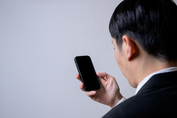 スマホを見る男性の後ろ姿