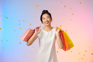 Happy asian woman in white dress holding shopping bags