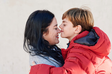 Loving mom and son hugging outside