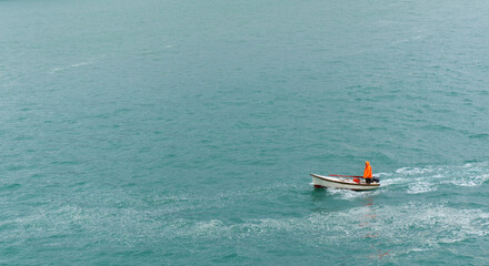 Obraz premium Fisherman in a motor boat on the background of the sea