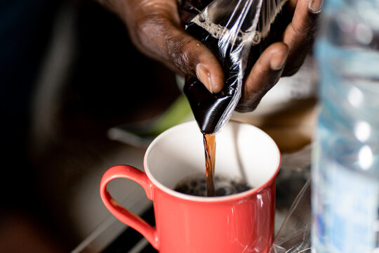 person pouring touba coffee into a cup