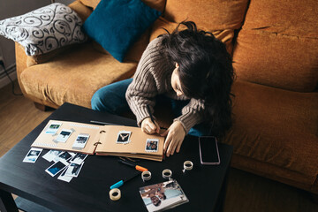 Woman making a scrapbook with polaroid photos