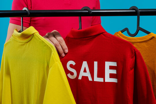 man grabbing a red t-shirt with the word sale