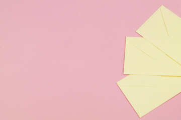 Three envelopes on pink background with copy space for text.