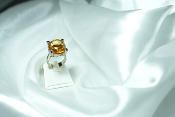 Yellow citrin Gems ring display show on white fabric satin. Luxury jewelry big head Gems