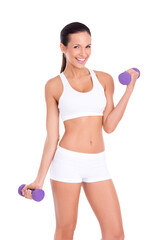 An attractive fit young woman smiling and lifting dumbbells isolated on a PNG background.