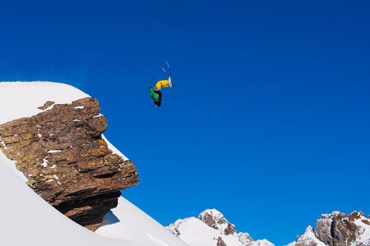 Skier doing backflip from mountain