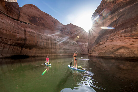 Two women paddleboarding in Lake Powell, Utah, USA