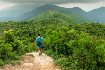 Dragon Back hiking trail on Hong Kong Island with person hiking back to camera. Moody Sky.