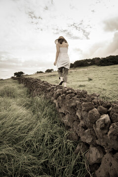Woman walking along stone wall, Ulupalakua Ranch, Kula, Maui, Hawaii Islands, USA