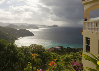 A house perched atop a hill commands a view of a bay below and distant islands.