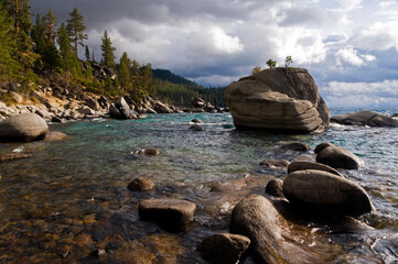 Dramatic clouds and turbulent water surround granite boulders on the east shore of Lake Tahoe, NV.