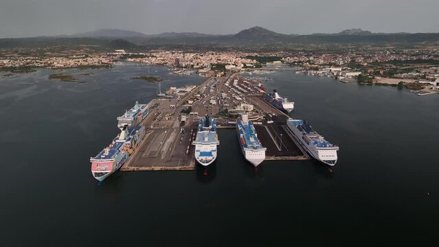 Tirrenia e Moby Lines, Olbia - Italy - Sardinia - 10 June 2022. Aerial view of the touristic and industrial port with line ferries in the harbour and urban panorama city