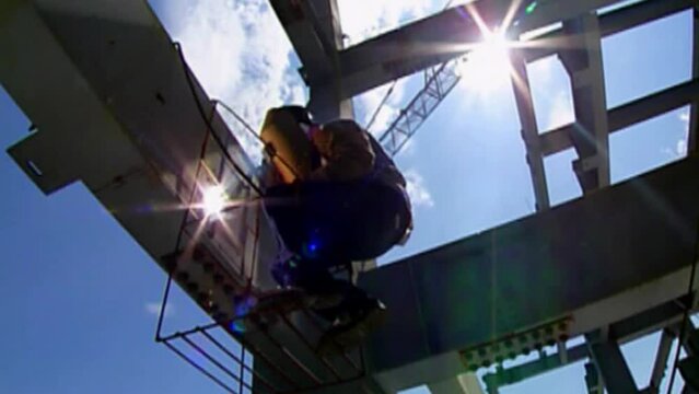 Worker With Protection Gear Welding Metal Plates
