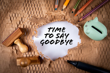 Time To Say Goodbye. Piggy bank and colored pencils on a torn cardboard background