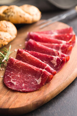 Fototapeta premium Smoked bresaola. Italian appetizer. Dried beef meat on cutting board.