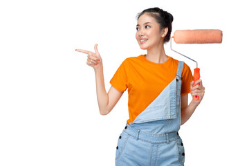 Asian young housewife holding a roller paint brush and pointing something