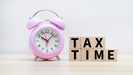 Cubic Blocks With Tax Time Word In Alarm Clock. concept of income tax collection.