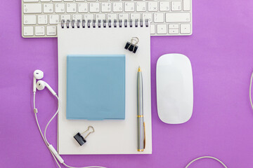 Notepad with pen on computer desk with headphones