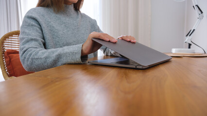Closeup image of hands close and open a laptop computer on table after finished using it