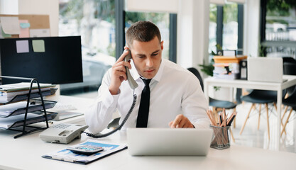 Fototapeta premium Happy business man have the joy of talking on the smartphone, tablet and laptopon the modern office