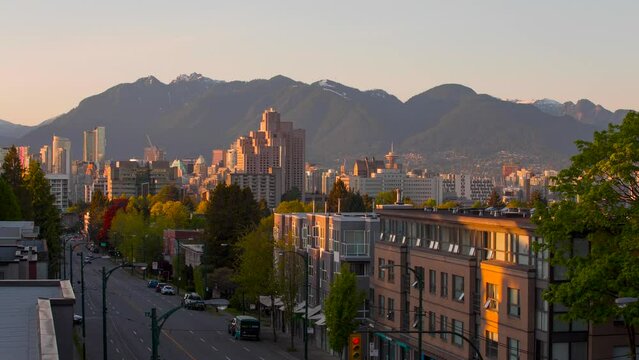 Beautiful time-lapse of a sunset in Vancouver, BC with the city's skyline featured. A panoramic view, showcasing the city's skyscrapers against the natural landscape of the mountains.