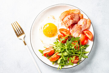 Healthy breakfast or lunch. Beacon, eggs and fresh salad. Top view on white.