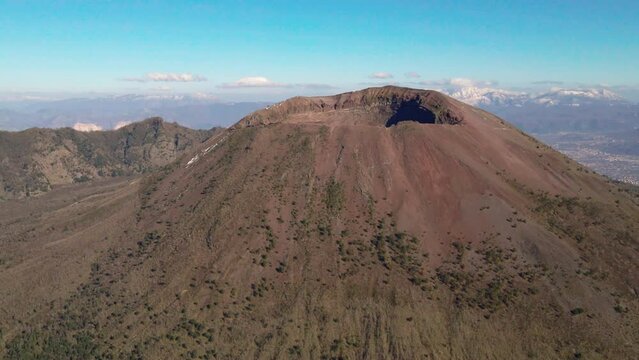 Mount Vesuvius summit, South Italy under sunny blue sky, pull back aerial view