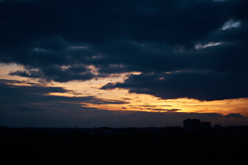 Bright sunset against the background of heavy dark clouds.