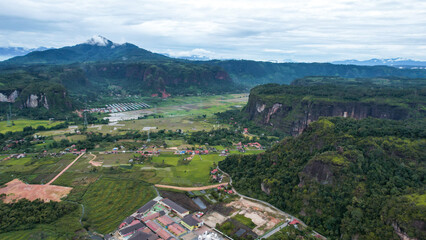 Fototapeta premium Aerial view of a beautiful landscape view of Harau Valley with mountains valley and grass view, Beautiful Minangkabau. 