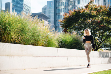 Fototapeta premium Fitness runner using mobile app while tracking progress outdoors